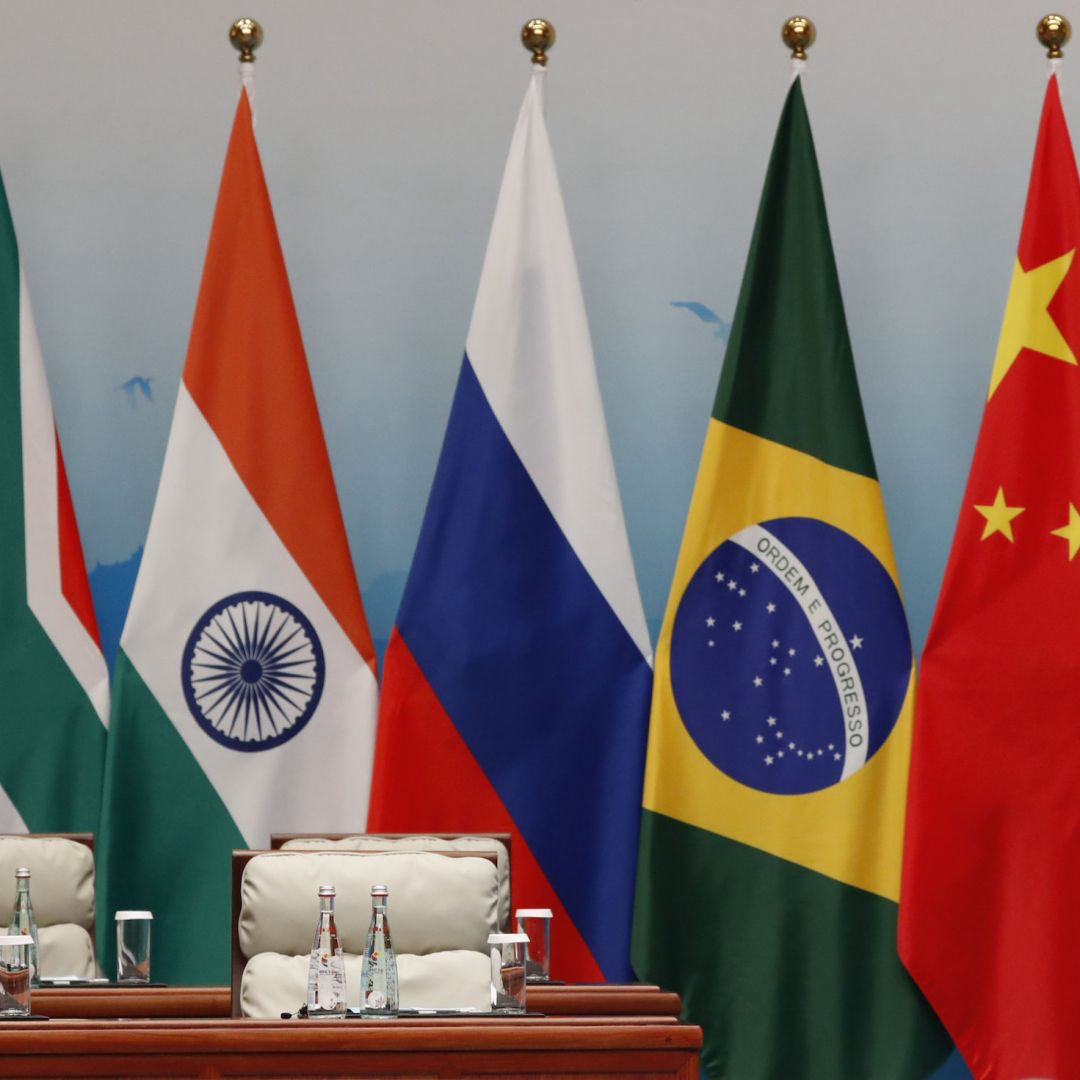 An attendant stands next to South African, Indian, Russian, Brazilian and Chinese flags during a BRICS summit in Xiamen, China, on Sept. 4, 2017. 