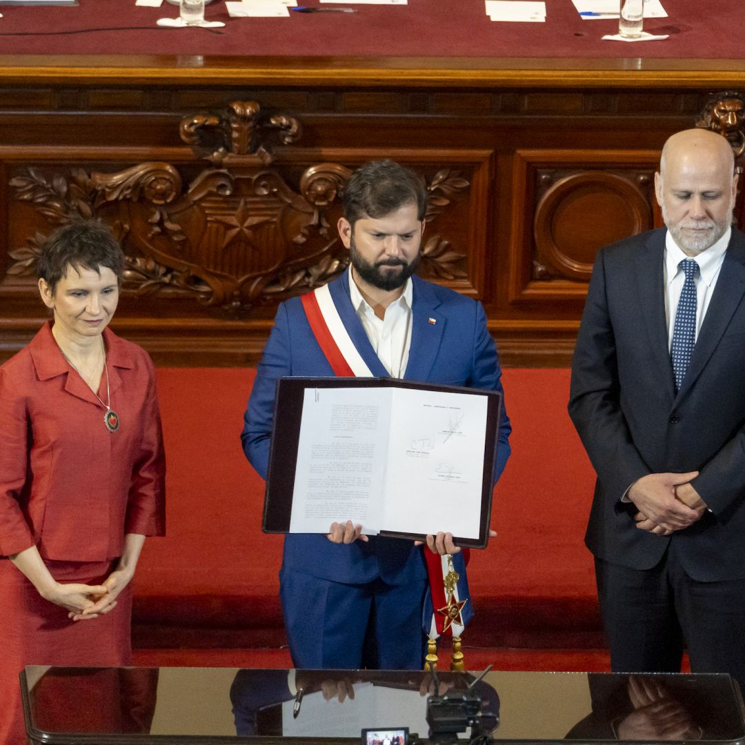 Chilean President Gabriel Boric (center) shows a signed decree that calls for a referendum to approve a new constitution on Nov. 7, 2023, in Santiago, Chile.