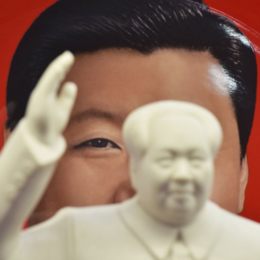 A decorative plate featuring an image of Chinese President Xi Jinping is seen behind a statue of late communist leader Mao Zedong at a souvenir store next to Tiananmen Square in Beijing, China, on Feb. 27, 2018. 