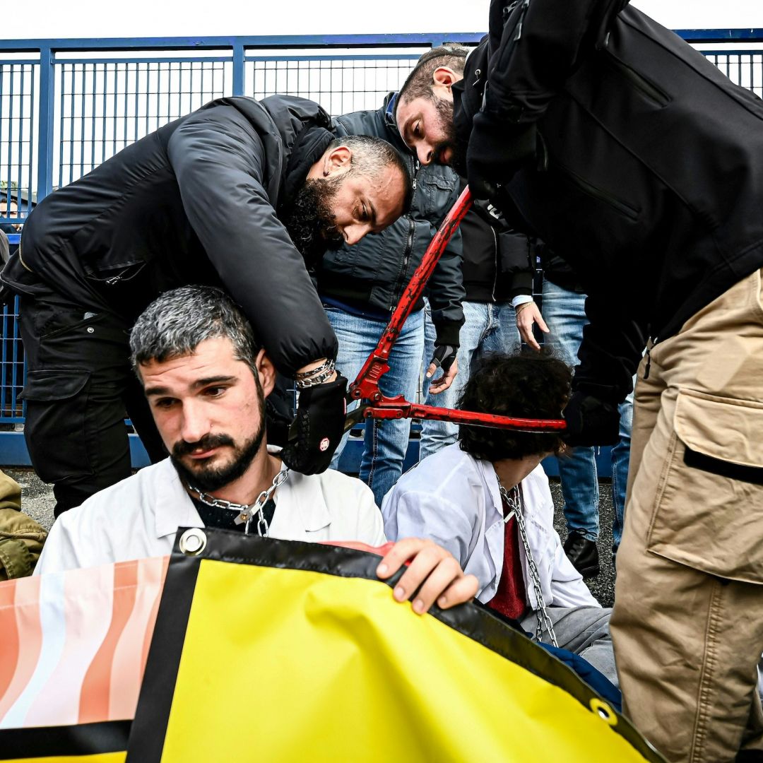Police officers remove a chain Nov. 10, 2022, from the neck of an activist as climate activists block the entrance of the Milano Linate Prime fixed-base operator airport facility in Milan. Police officers remove a chain Nov. 10, 2022, from the neck of an activist as climate activists block the entrance of the Milano Linate Prime fixed-base operator airport facility in Milan.