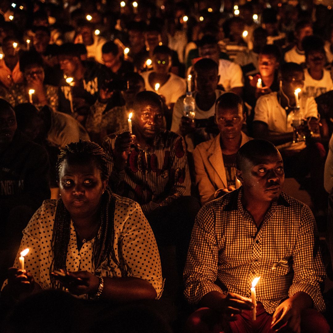 People hold candles during a ceremony commemorating the 25th anniversary of the Rwandan Genocide on April 7, 2019, at the Amahoro Stadium in Kigali. 