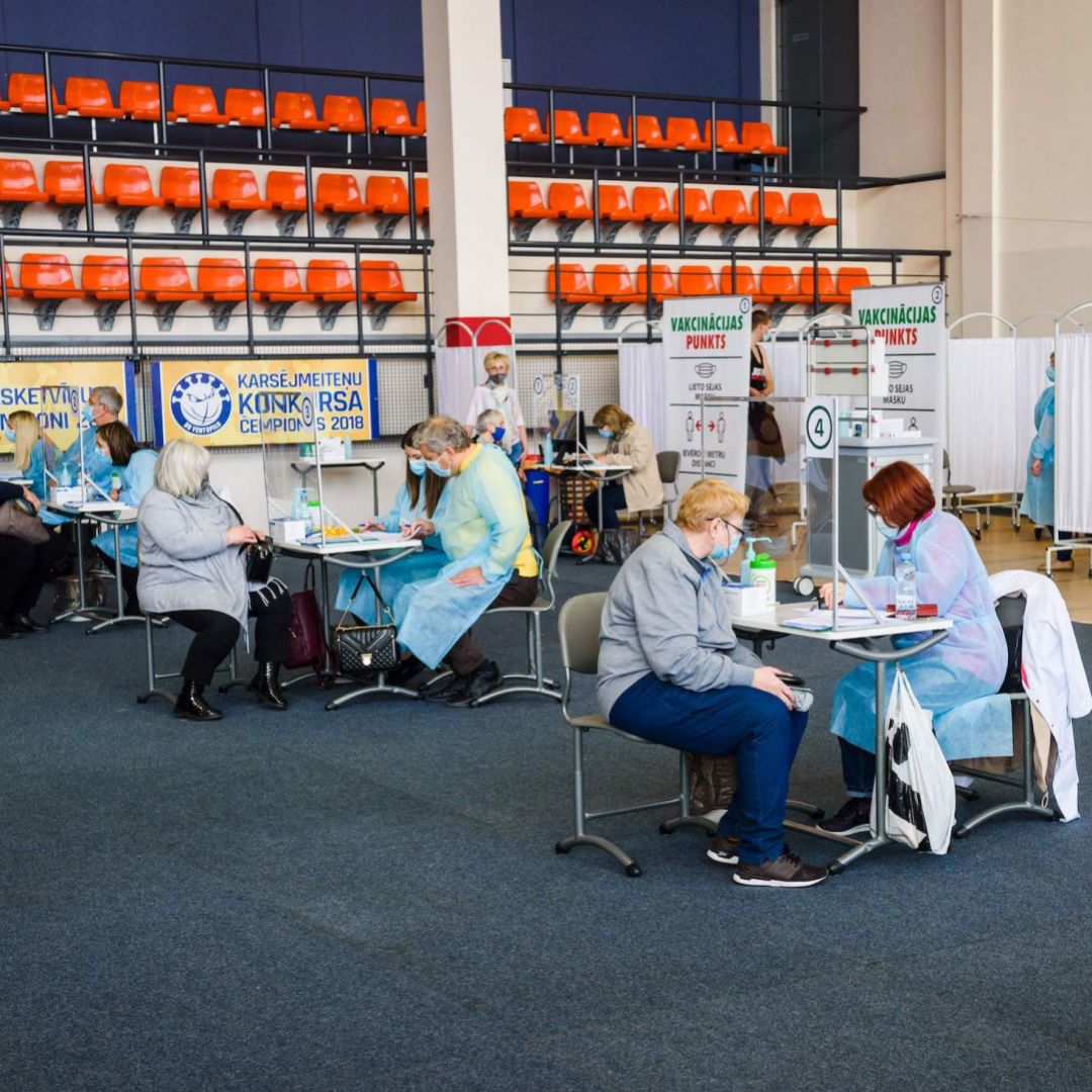 People wait to receive the COVID-19 vaccine at a community center in Latvia on March 30, 2021. 