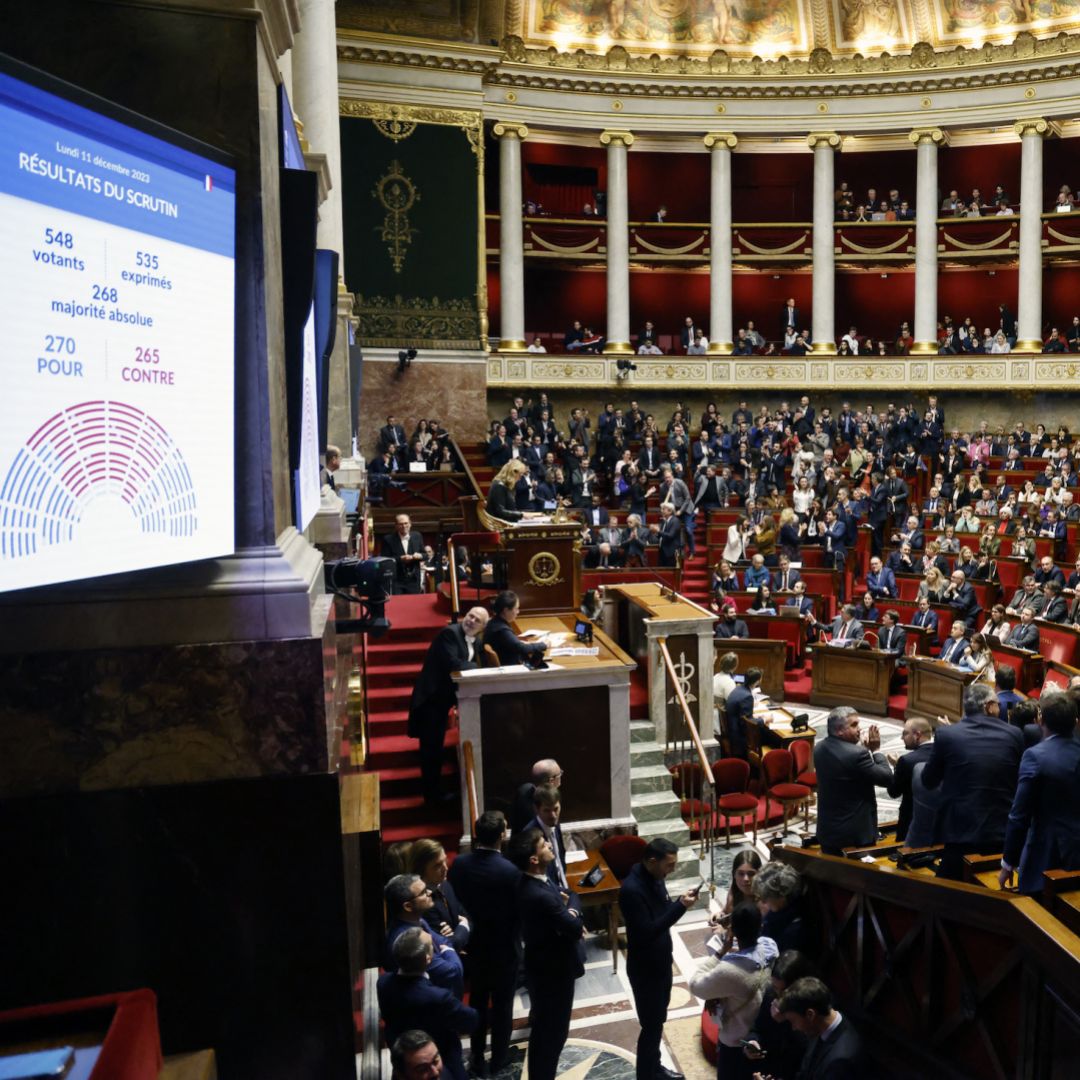 Vote results are seen on a screen (left) after a debate on the French government's draft immigration law in the National Assembly in Paris, France, on Dec. 11, 2023. 