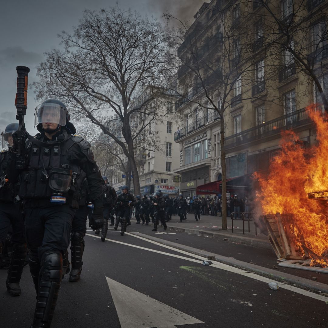 Riot police walk past a street fire during violent clashes over the government's reform of the pension system March 23, 2023, in Paris.