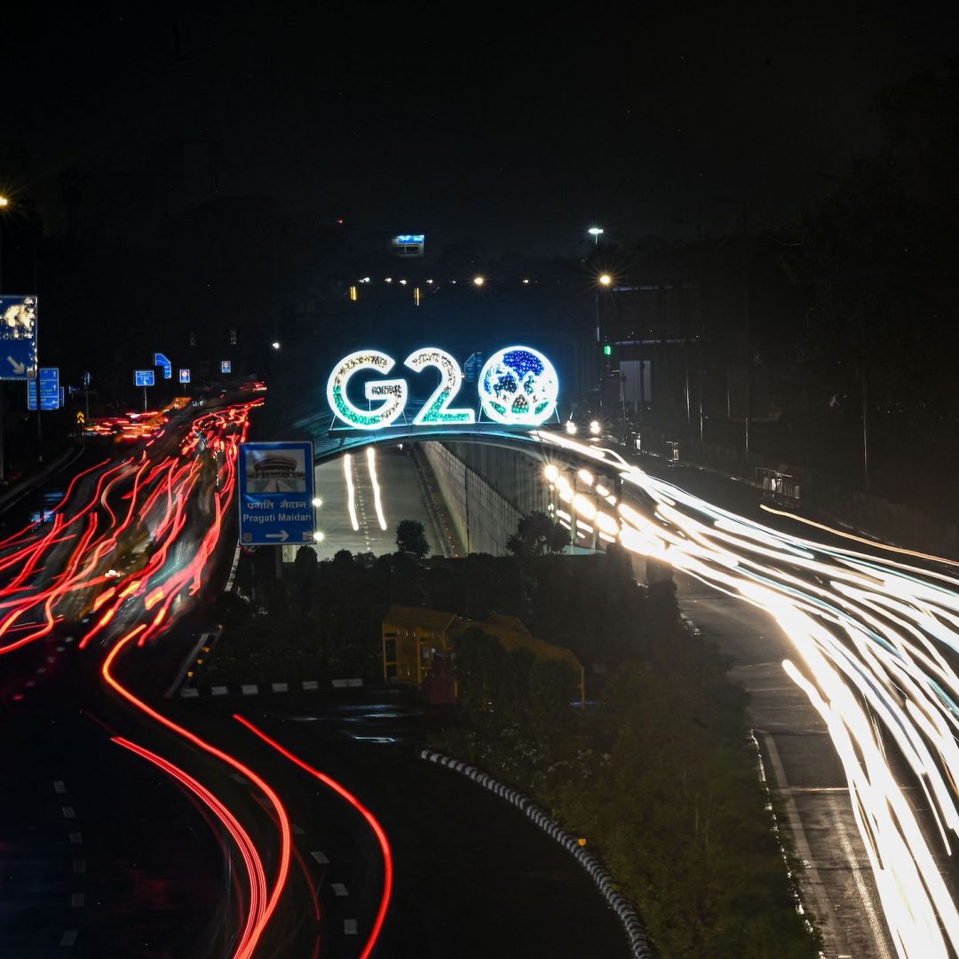 Vehicles drive past the logo of the G-20 Summit on Aug. 10, 2023, in New Delhi.