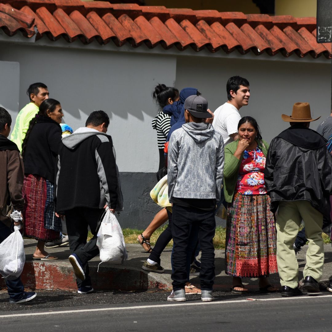 Migrants deported from the United States stand outside an air force base in Guatemala City on Dec. 12, 2019.