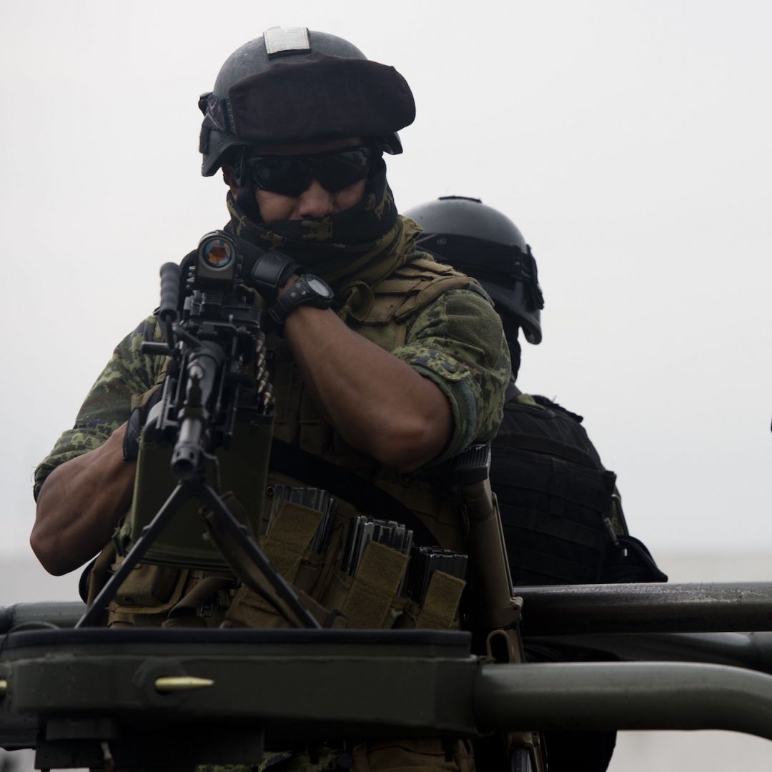 Soldiers stand guard as an alleged leader of the Gulf Cartel is presented to the media May 25, 2014, at the hangar of the Attorney General's office at Benito Juarez International Airport in Mexico City.