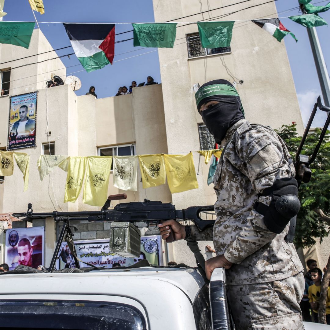 A masked Hamas militant mans a machine gun in the back of a pickup truck in the Palestinian city of Rafah, located in the southern Gaza Strip, on Oct. 17, 2019. The yellow flags of the Palestinian party Fatah can also be seen in the background. 