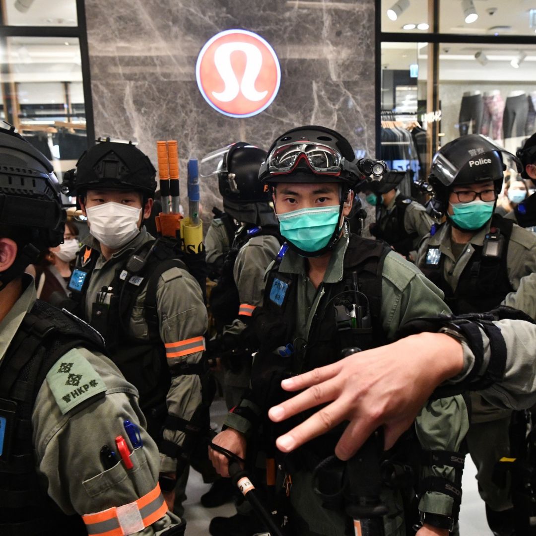 Riot police wear face masks, as a precautionary measure against the COVID-19 coronavirus, as they carry out a crowd dispersal operation in a shopping mall during a protest by pro-democracy supporters in the town of Shatin in Hong Kong on May 1, 2020.