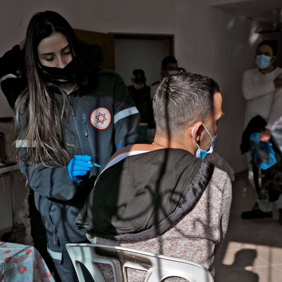 A health worker administers a dose of the Pfizer-BioNtech COVID-19 vaccine at a mobile clinic near Moshav Dalton in northern Israel on Feb. 22, 2021. 