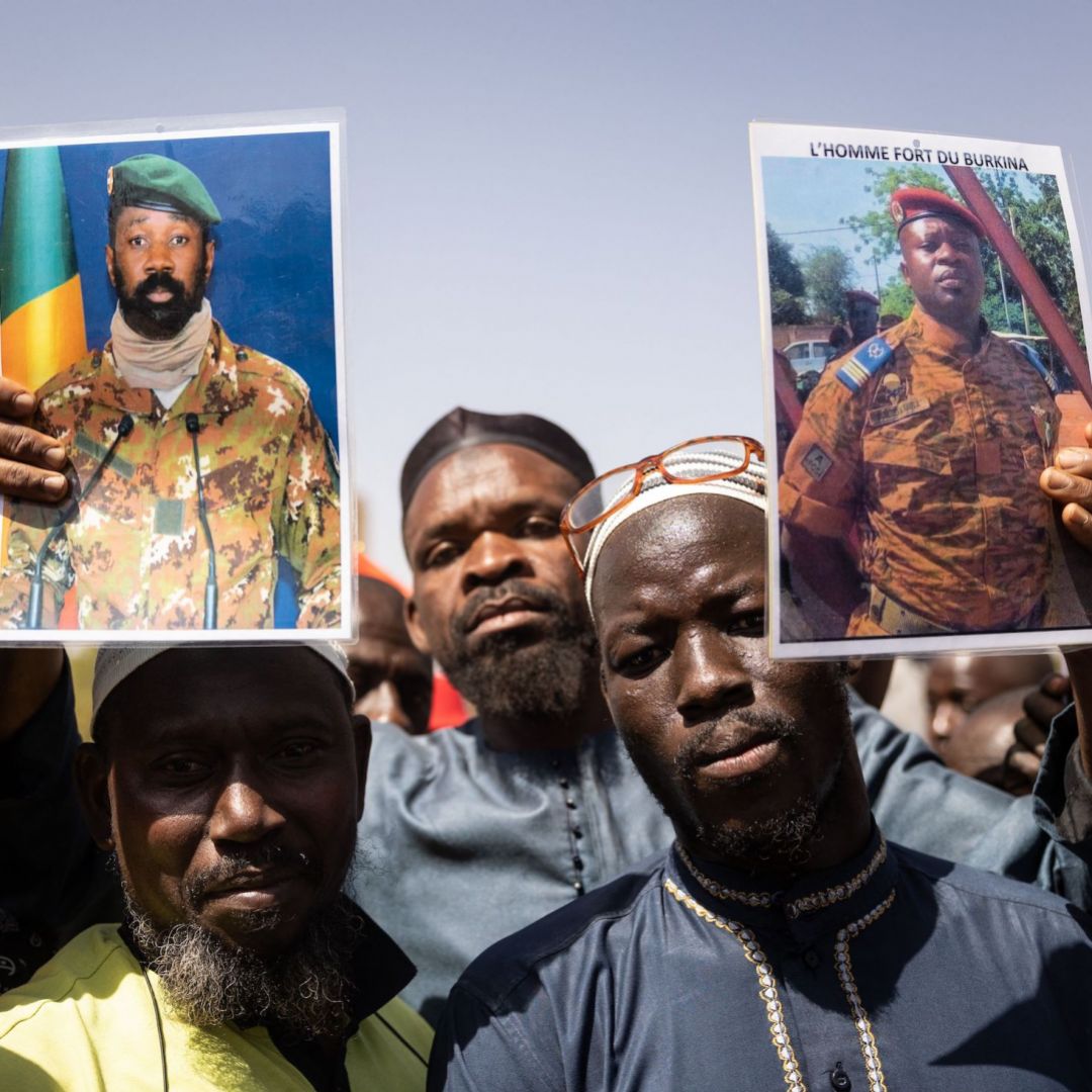 Demonstrators in Ouagadougou, Burkina Faso, hold up photos of Malian coup leader Assimi Goita (who seized power in Mali for the second time in a May 2021 coup) and Burkina Faso coup leader Paul-Henri Sandaogo Damiba on Jan. 25, 2022.