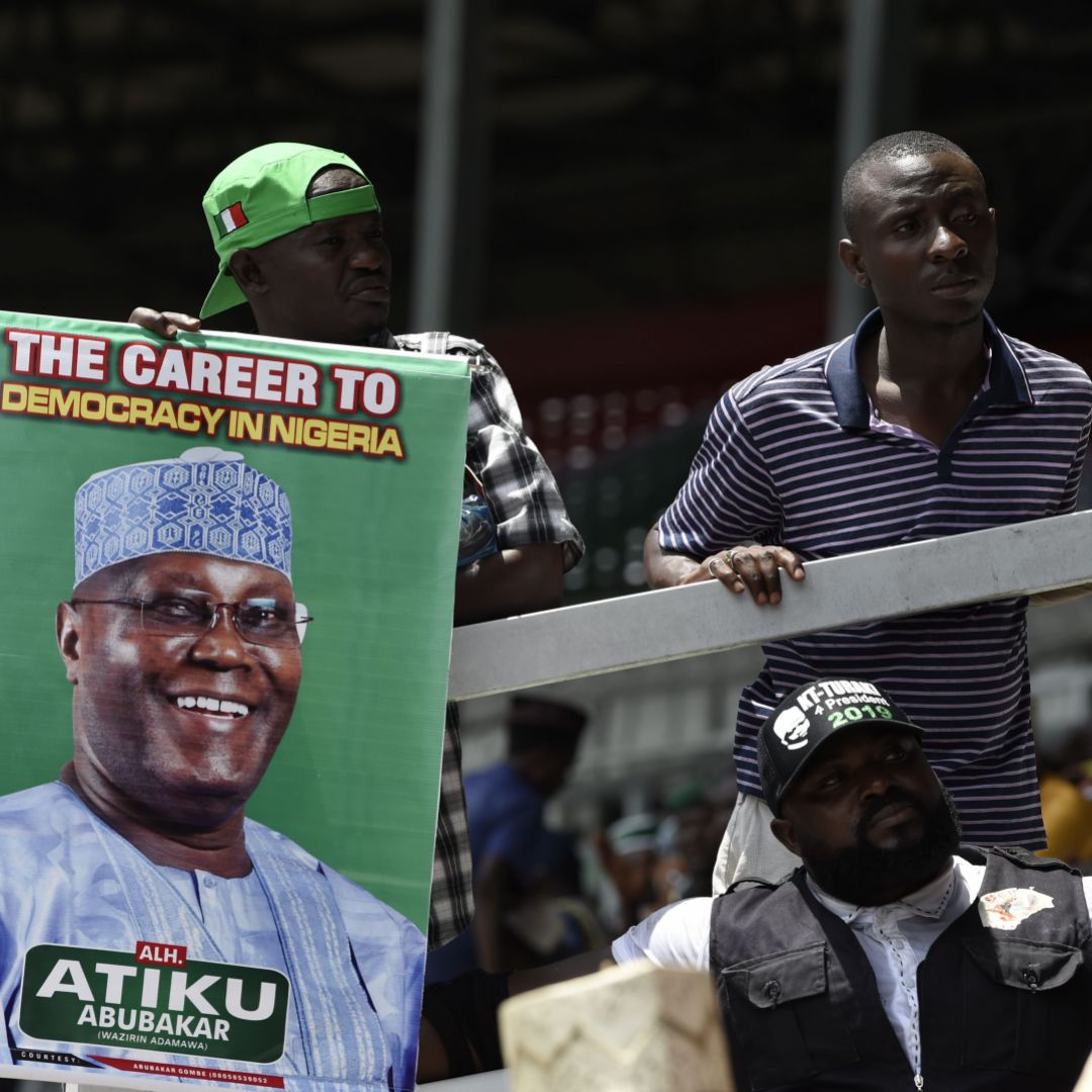 Supporters of Atiku Abubakar of the People's Democratic Party hold a campaign poster for the candidate who is challenging the incumbent Muhammadu Buhari. Atiku Abubakar, the candidate from the resurgent People's Democratic Party, hopes to unseat President Muhammadu Buhari, whose health concerns are a factor for Nigerian voters.