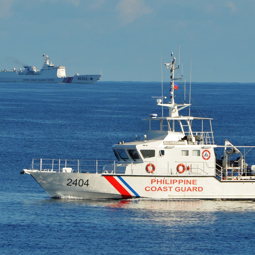 Philippine and Chinese coast guard ships sail past each other in the South China Sea on May 14, 2019. 