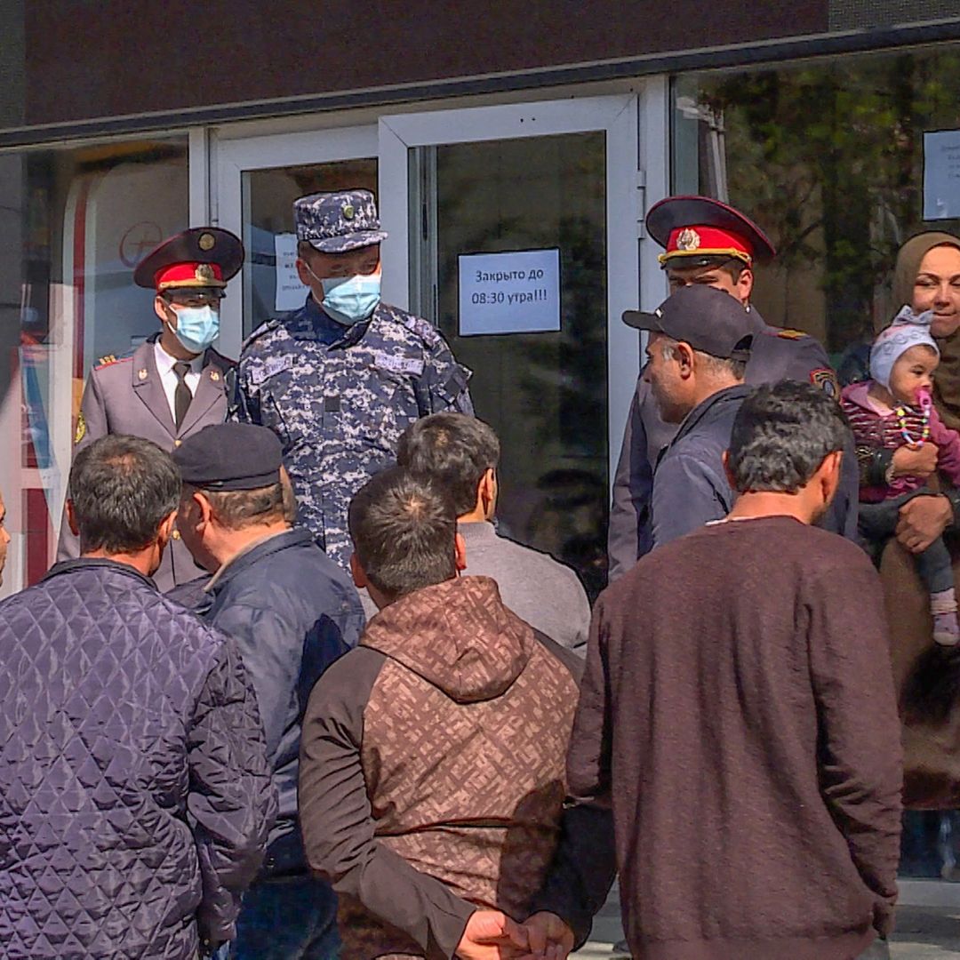 People seeking to return to work in Russia line up outside Tajikistan's state air ticket agency in the capital of Dushanbe on April 8, 2021. 