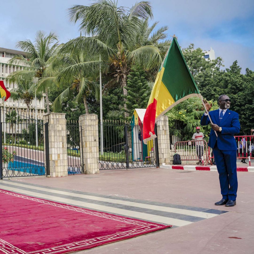 A man holds a Senegalese flag in front of the Parliament in Dakar on Sept. 12, 2022, ahead of the first parliamentary session since the July 2022 legislative elections.