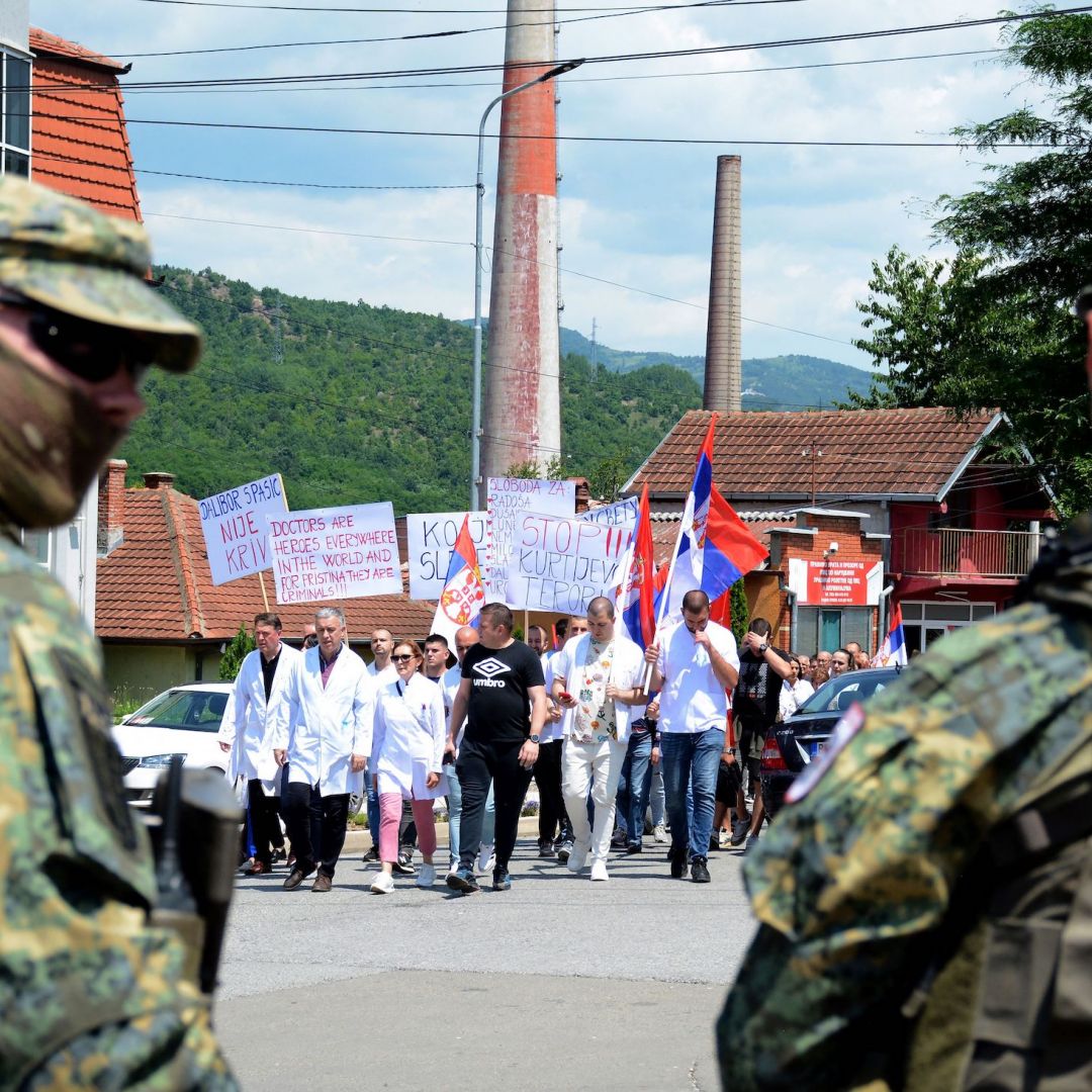 NATO peacekeepers stand guard as hospital employees lead a protest march of ethnic Serbs in northern Kosovo on June 19, 2023. 