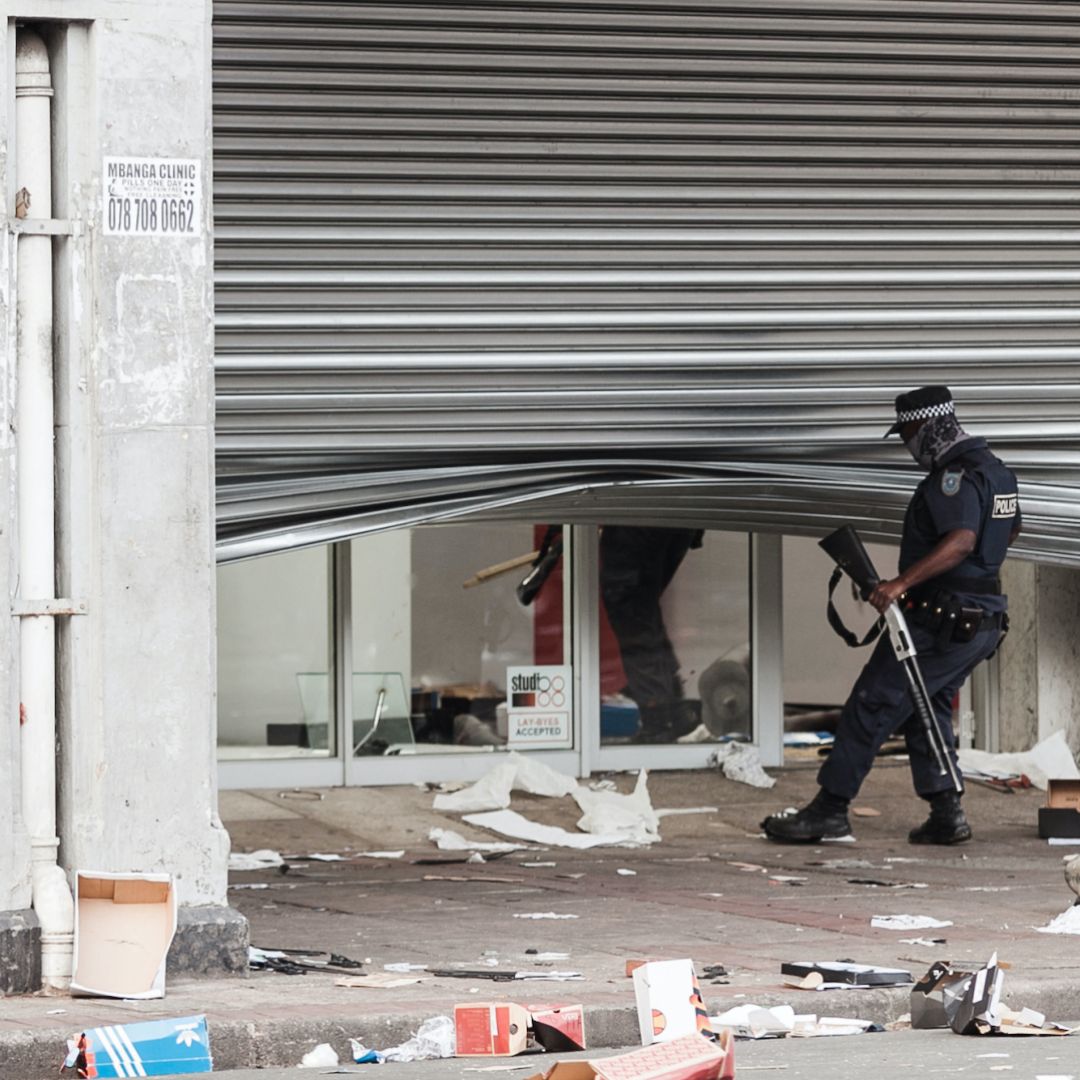 A police officer scans a looted retail store in central Durban, South Africa, on July 11, 2021. 