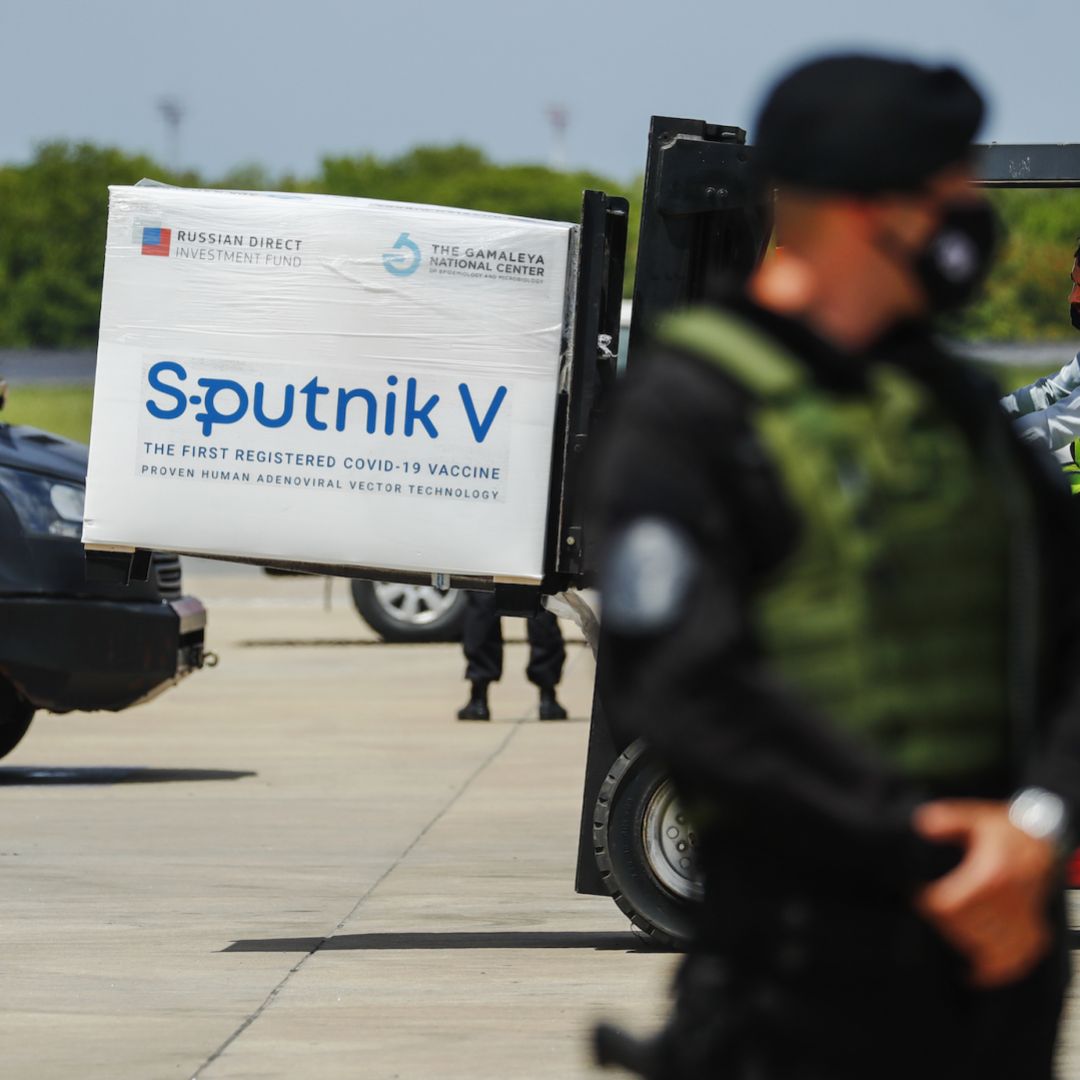 A member of the airport police stands guard as a forklift unloads a container full of Russia’s Sputnik V COVID-19 vaccine from a plane in Ezeiza, Argentina, on Jan. 16, 2021. 