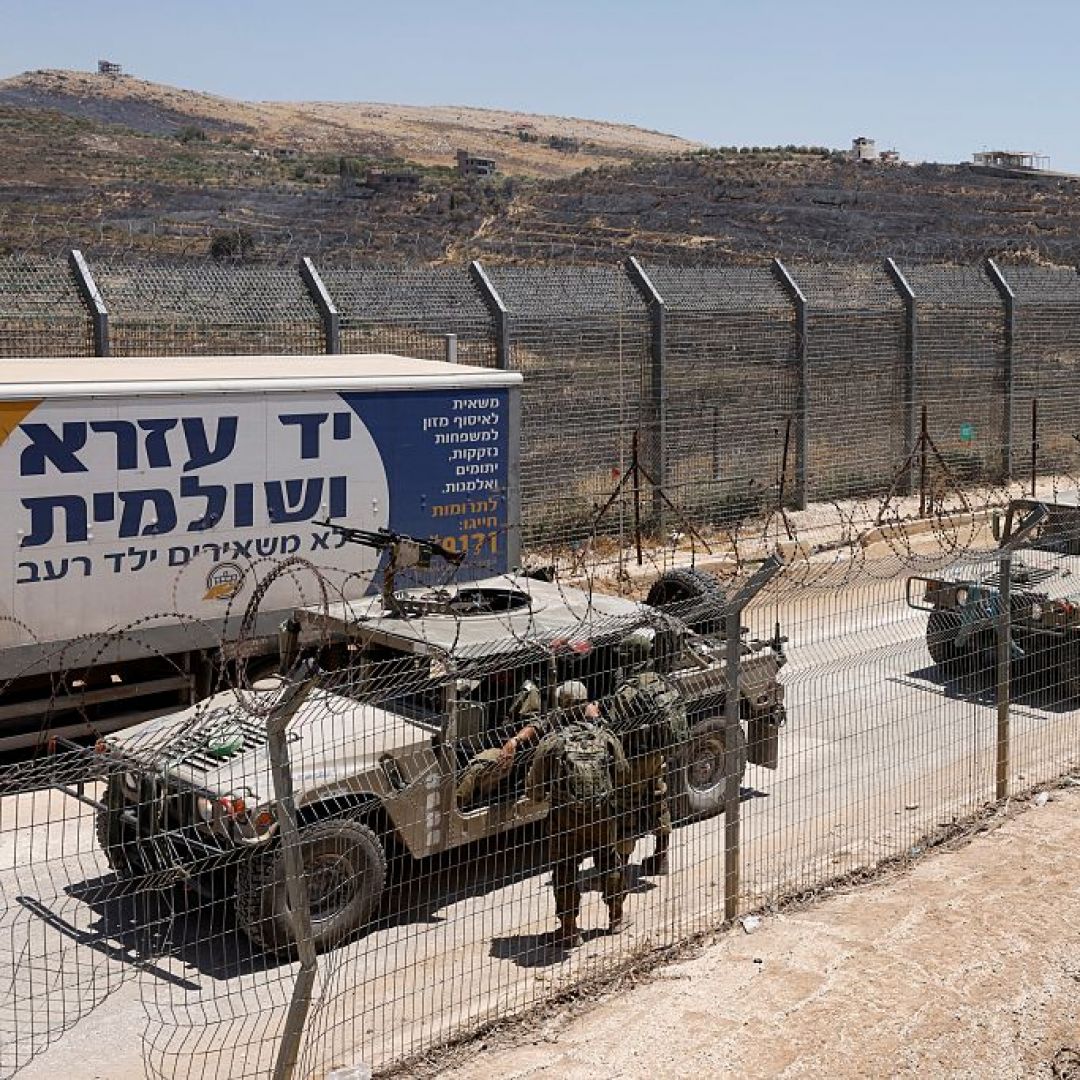 Israeli military vehicles drive along the border fence into Israel, near the town of Majdal Shams, in the Israeli-annexed Golan Heights, on July 17, 2025.