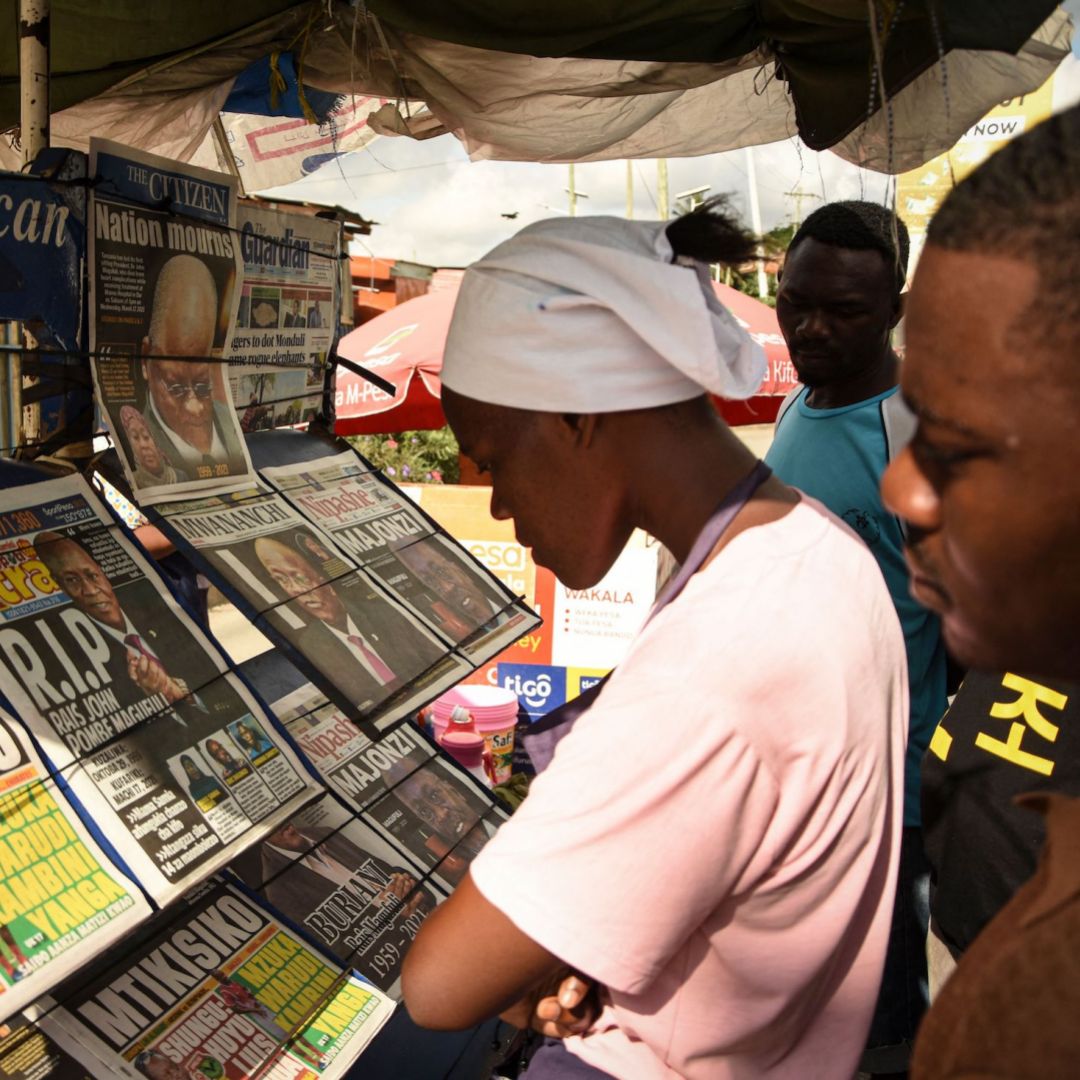 People read newspapers announcing the death of Tanzanian President John Magufuli in Dar es Salaam on March 18, 2021. 