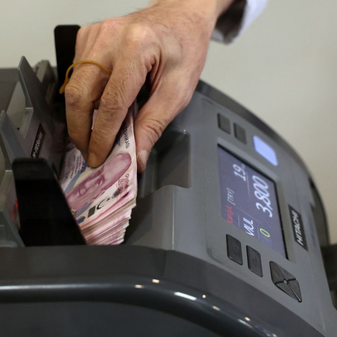 A teller uses a machine to count Turkish lira banknotes at a foreign exchange office in Ankara, Turkey, on July 20, 2023.