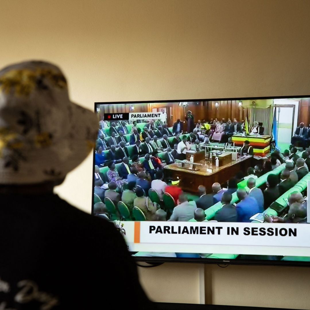 A Ugandan citizen watches a television broadcast of lawmakers holding a session on an anti-LGBTQ bill in the country's parliament on March 21, 2023. 