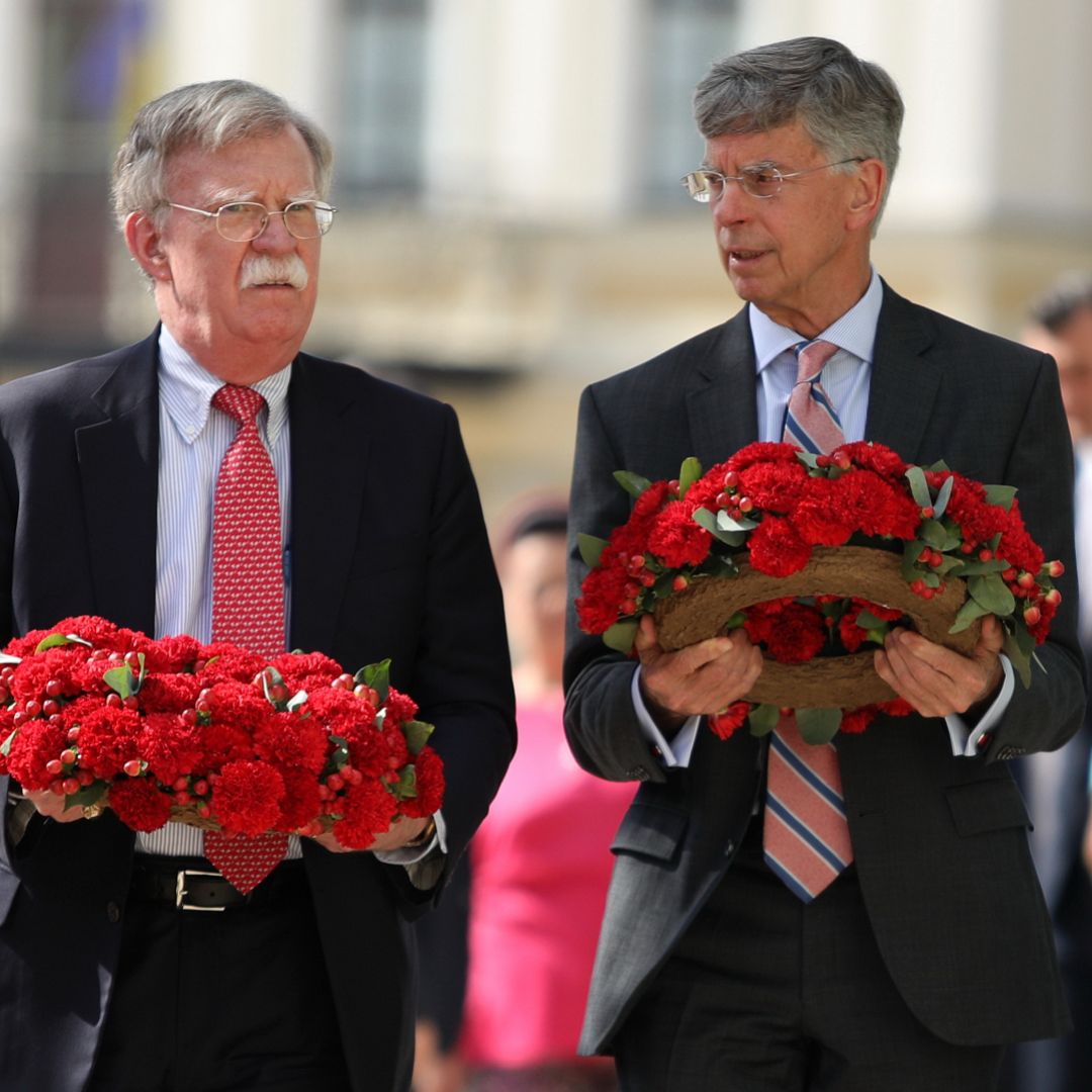 U.S. national security adviser John Bolton (L) and U.S. Ambassador to Ukraine William Taylor prepare to lay flowers commemorating Ukrainian soldiers who died in eastern Ukraine during a visit to Kyiv on Aug. 27, 2019.