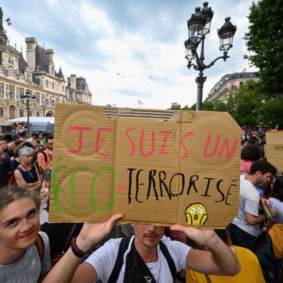 A protester holds a sign reading "I'm an eco-terrorised" during a rally to support the environmental movement Les Soulevements de la Terre (Uprisings of the Earth) near city hall in Paris, France, on June 21, 2023.