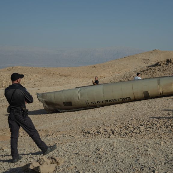 An Israeli police officer stands near the remains of an Iranian missile on Oct. 2, 2024, near the Dead Sea, Israel. 