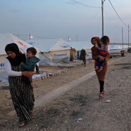 Syrian refugees walk outside a tent at a camp near the Iraqi Kurdish town of Bardarash on Oct. 18, 2019. Syrian refugees walk outside a tent at a camp near the Iraqi Kurdish town of Bardarash on Oct. 18, 2019.