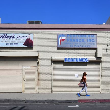 A woman walks past closed shopfronts in what would be a normally busy fashion district in Los Angeles, California, on May 4, 2020. A woman walks past closed shopfronts in what would be a normally busy fashion district in Los Angeles, California, on May 4, 2020.