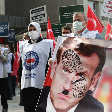 Protesters hold a sign with a picture of French President Emmanuel Macron in Ankara, Turkey, on Oct. 27, 2020. On Oct. 20, Macron blamed radical Islam for the violence that led to the recent beheading of a teacher in a Paris suburb. Protesters hold a sign with a picture of French President Emmanuel Macron in Ankara, Turkey, on Oct. 27, 2020. On Oct. 20, Macron blamed radical Islam for the violence that led to the recent beheading of a teacher in a Paris suburb.