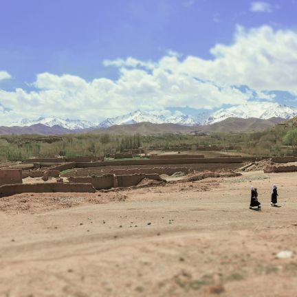 Afghanistan suffers from an increasingly stark urban-rural divide. Villagers walk across a striking Afghan rural landscape.