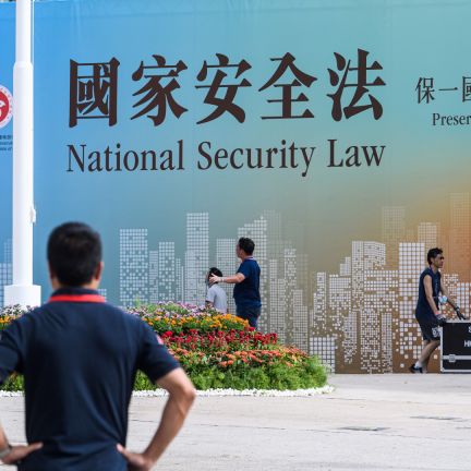 Technicians in Hong Kong walk next to a banner supporting China’s new national security law following a flag-raising ceremony marking the 23rd anniversary of the city’s British handover on July 1, 2020. Technicians in Hong Kong walk next to a banner supporting China’s new national security law following a flag-raising ceremony marking the 23rd anniversary of the city’s British handover on July 1, 2020.