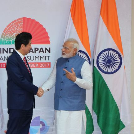 Indian Prime Minister Narendra Modi shakes hands with Japanese Prime Minister Shinzo Abe during a 2017 summit. Japan is a key ally in India's ambitions to compete with China. Indian Prime Minister Narendra Modi (right) shakes hand with Japanese Prime Minister Shinzo Abe during the annual India-Japan summit on Sept. 14, 2017. Behind the two world leaders are their countries' respective flags.