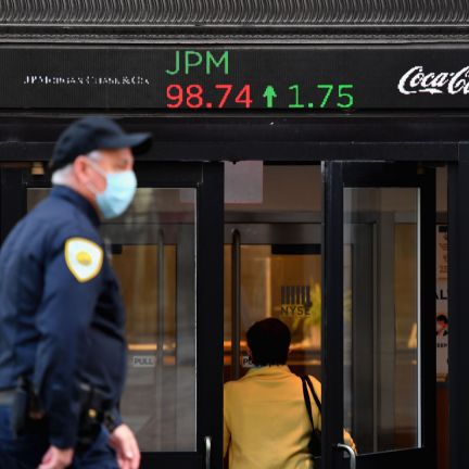 People wearing masks walk by the New York Stock Exchange (NYSE) in lower Manhattan on Oct. 5, 2020, in New York City. People wearing masks walk by the New York Stock Exchange (NYSE) in lower Manhattan on Oct. 5, 2020, in New York City.