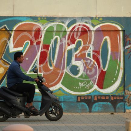 A man rides past graffiti alluding to Vision 2030 A man rides past graffiti alluding to Vision 2030