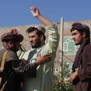 A Taliban fighter (L) frisks men at a checkpoint after a blast during Friday prayers Sept. 2, 2022, in Gazargah mosque in Herat.