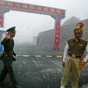 A Chinese soldier (L) and an Indian soldier (R) stand guard at the Chinese side of the ancient Nathu La border crossing between India and China.