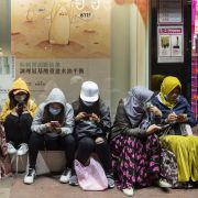 Women wearing sanitary masks sit on a street in Hong Kong. Women sit along the side of a street in Hong Kong on Jan. 28. They’re each wearing sanitary masks to protect themselves from the coronavirus.