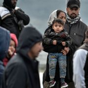 Refugees and migrants stand at a port upon arriving at the Greek island of Lesbos on March 7, 2020. Refugees and migrants stand at a port upon arriving at the Greek island of Lesbos on March 7, 2020.