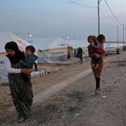 Syrian refugees walk outside a tent at a camp near the Iraqi Kurdish town of Bardarash on Oct. 18, 2019. Syrian refugees walk outside a tent at a camp near the Iraqi Kurdish town of Bardarash on Oct. 18, 2019.