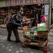 A woman pushes a cart down a street in Beijing, China, on March 5, 2021. A woman pushes a cart down a street in Beijing, China, on March 5, 2021.