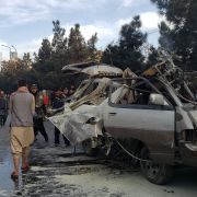People gather next to a damaged bus damaged in a deadly bomb blast in Kabul, Afghanistan, on Nov. 17, 2021. 