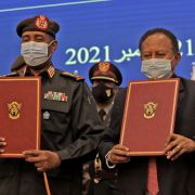 Sudan’s military chief (left) and prime minister show documents during a deal-signing ceremony in Khartoum on Nov. 21, 2021. 