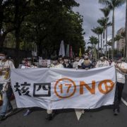 Activists march down a street in Taipei, Taiwan, to protest restarting construction on a nuclear power plant on Dec. 4, 2021. 