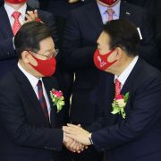 Yoon Suk Yeol (front right), the presidential candidate for South Korea's main opposition party, shakes hands with the ruling party’s candidate, Lee Jae-myung, in Seoul on Jan. 3, 2022. 