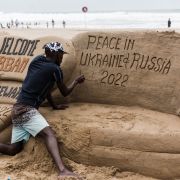 A sand sculptor writes a message calling for peace between Ukraine and Russia on a beach in Durban, South Africa, on Feb. 27, 2022. 