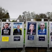 A photo shows presidential candidates' election posters on a billboard in La Baussaine, western France, on March 29, 2022. 
