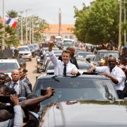 During the final day of the African tour that also included visits to Cameroon and Benin, French President Emmanuel Macron (left) waves to a crowd through the roof of a car in Bissau with Guinea-Bissau's President Umaro Sissoco Embalo. 